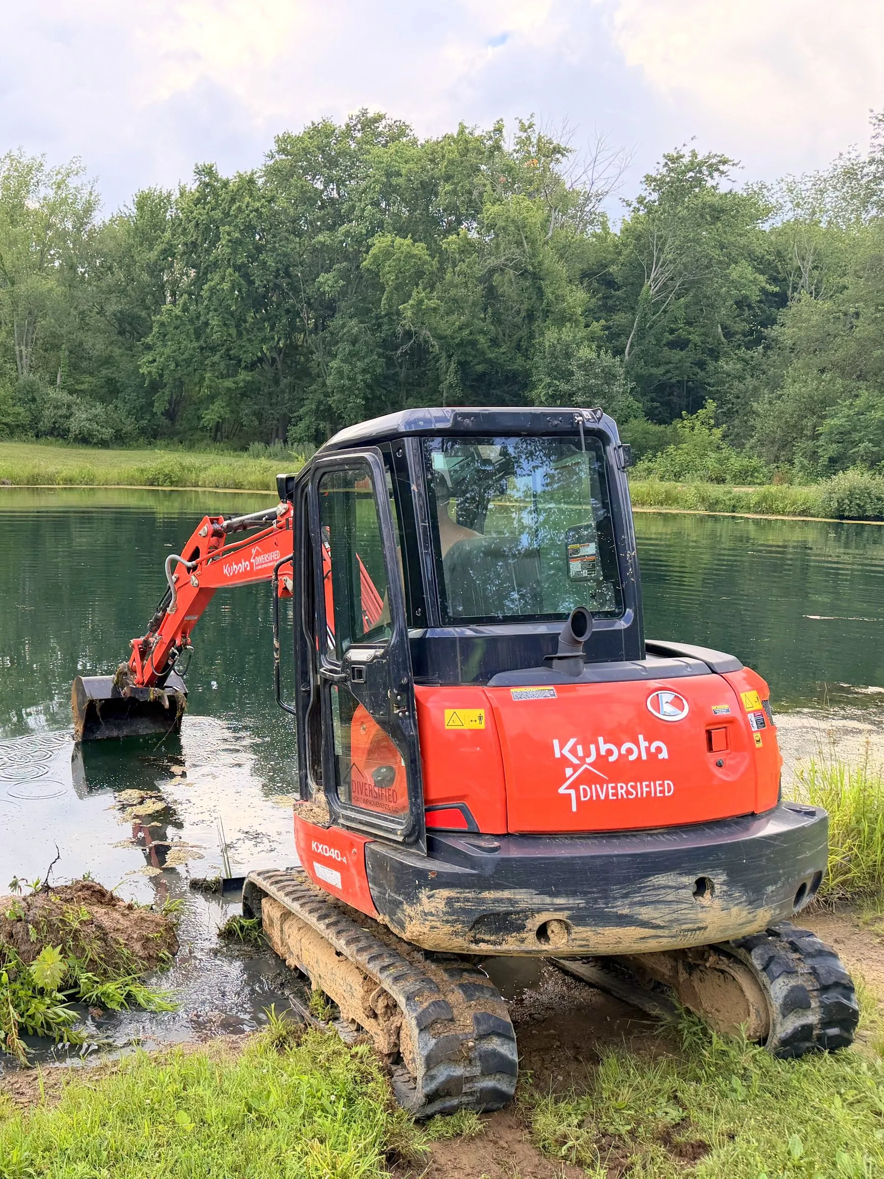 Kubota KX040 mini excavator cleaning out a pond