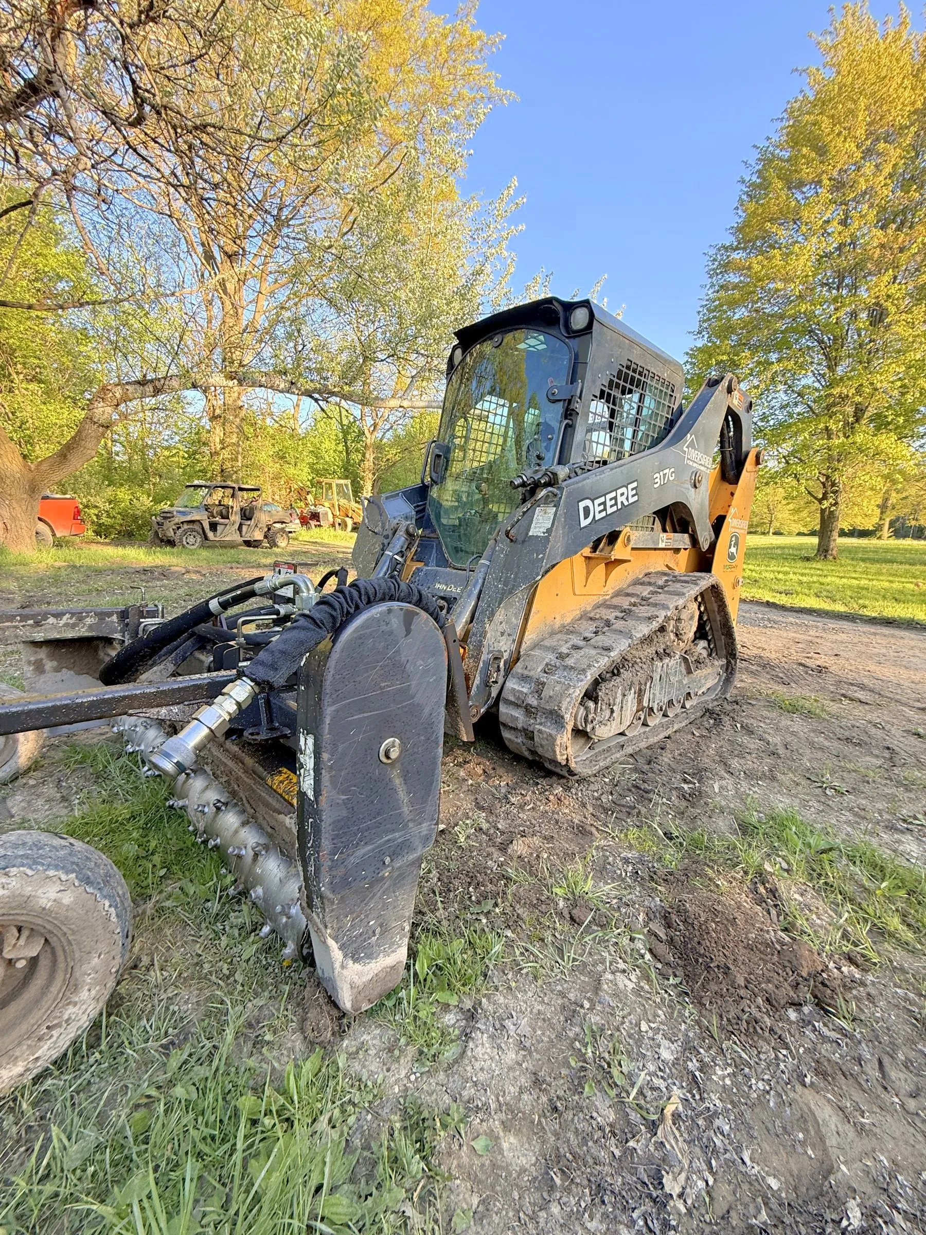John Deere 317G track loader with a soil conditioner