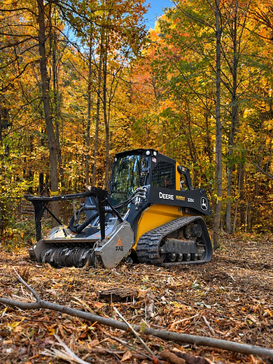 DHI equipment: a John Deere 325G with a forestry mulcher, a branded Kubota mini excavator, a soft wash rig, a John Deere 317G and a Ford F-450 dually