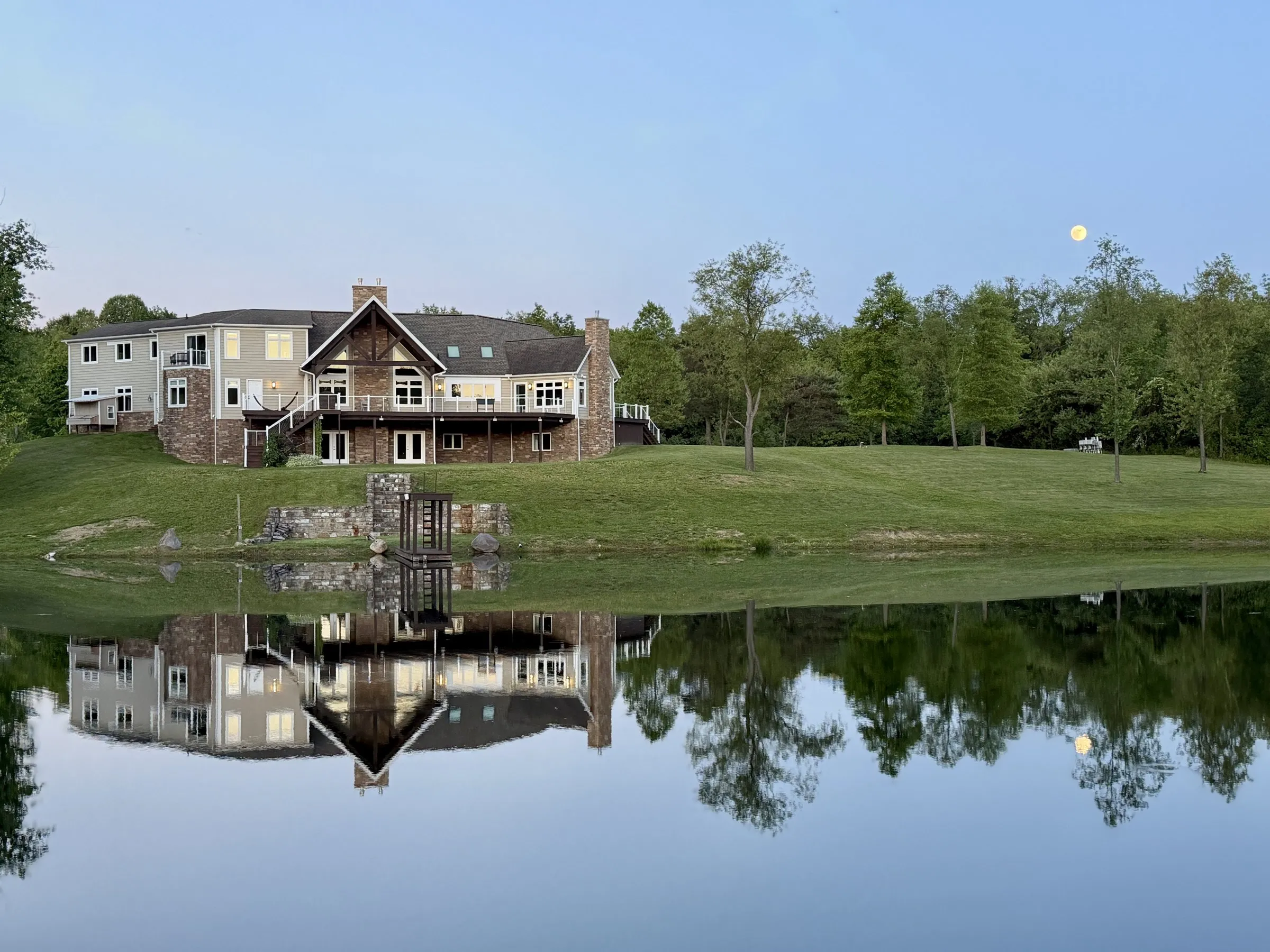 Two-level deck across the back of a lakeside home at dusk