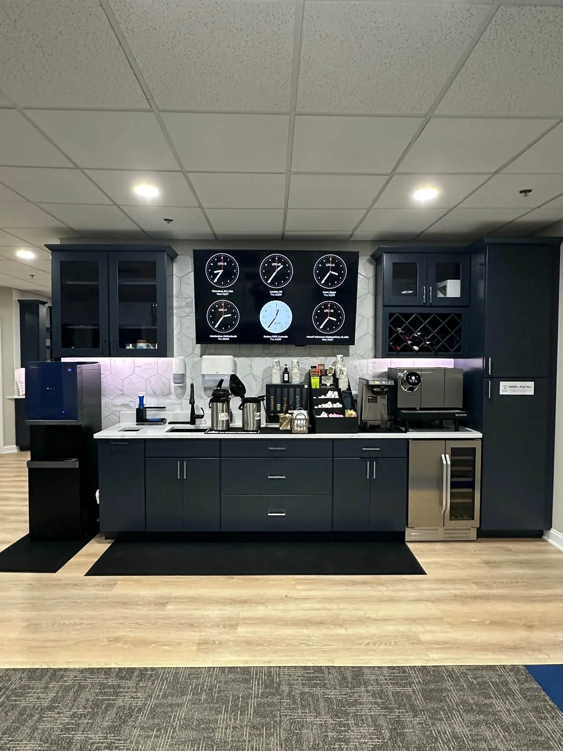 Custom coffee bar with navy cabinets, quartz counter and hex tile backsplash
